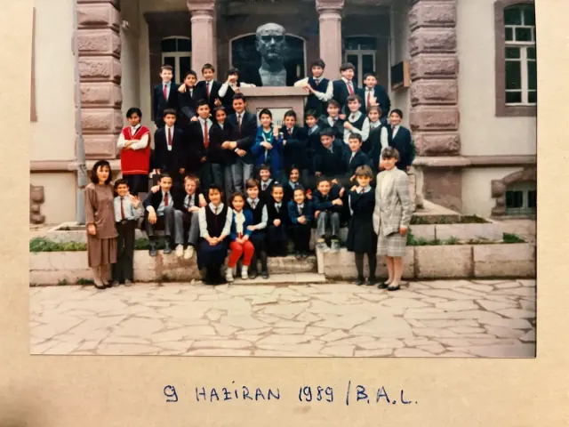 Okul binasının merdivenlerinde, Atatürk büstünün önünde toplu sınıf fotoğrafı